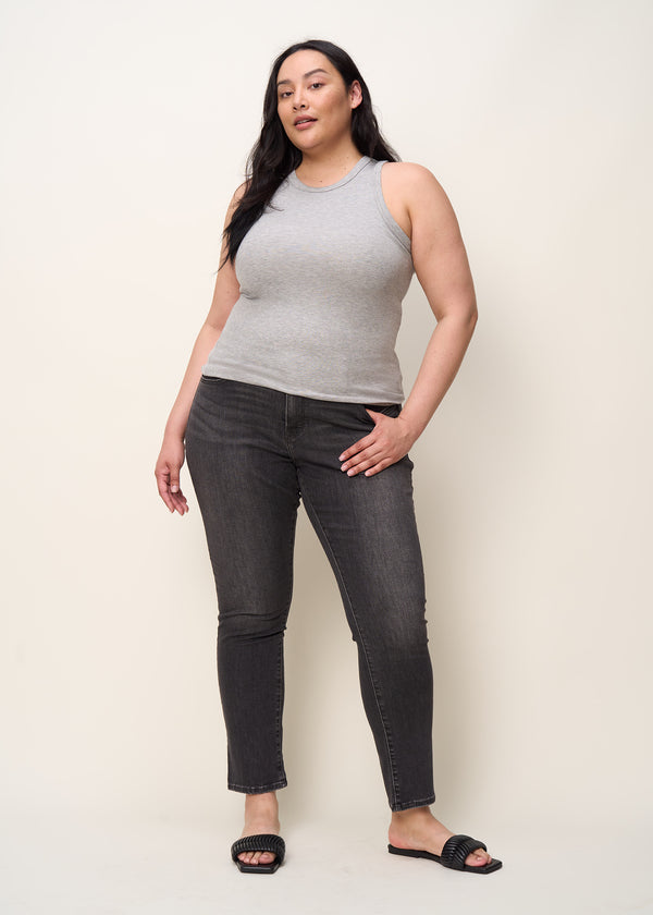 Woman in crewneck tank top made of soft tencel rib knit fabric with racerback detail and binding at neck and armholes in color heather grey paired with black denim and black sandals
