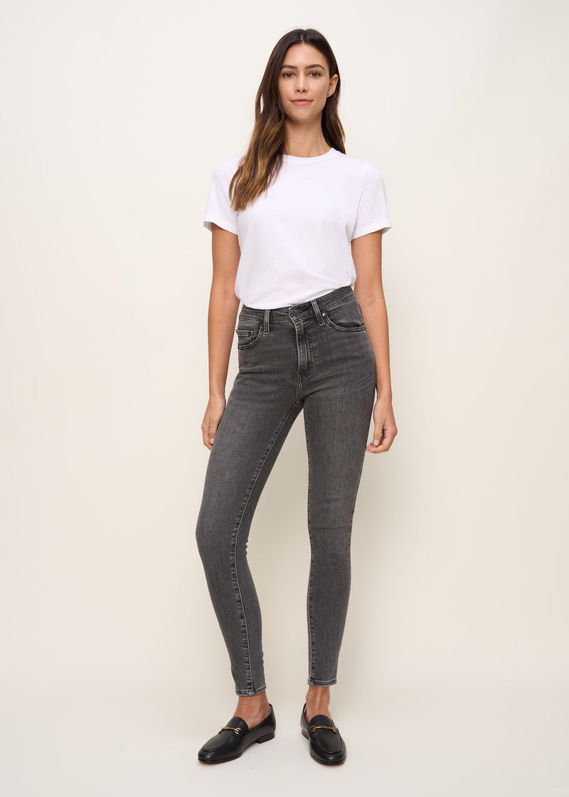 Woman in relaxed fit crew neck t-shirt with short sleeves made of organic and recycled cotton jersey and eco-friendly dyes in true white paired with black denim pants