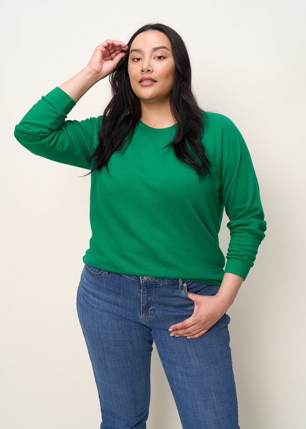 Woman in crewneck raglan sweatshirt made of organic and recycled cotton French Terry in color Kelly Green, front