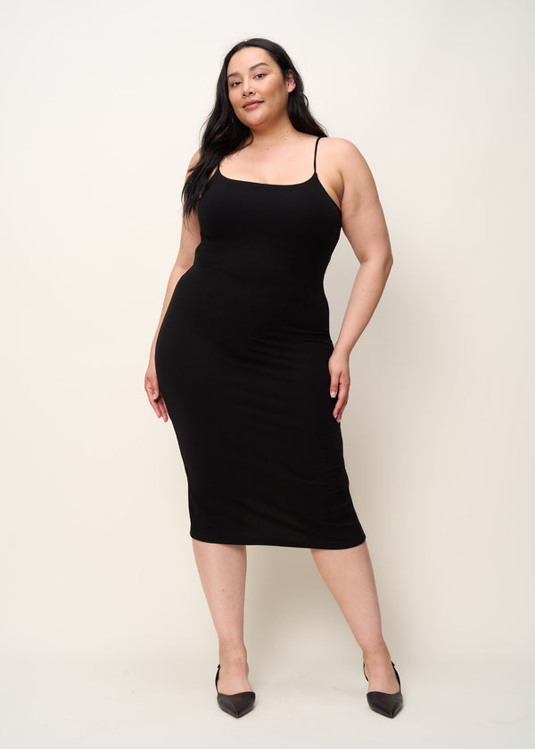 Woman in comfortably form fitted, spaghetti strap midi dress including a back slip and built-in shelf bra made of mid-weight and soft Tencel™ Lyocell stretch rib fabric and eco-friendly dyes in color onyx black, front