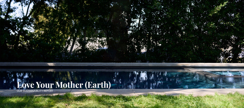 Image of an outdoor pool surrounded by trees and grass. 