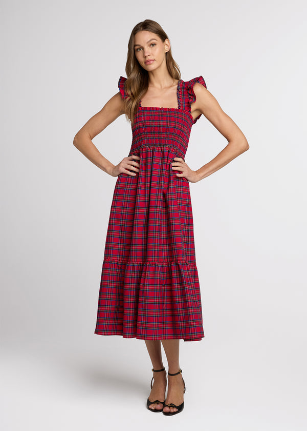 Woman in red plaid midi dress with her hands on her hips. Front.