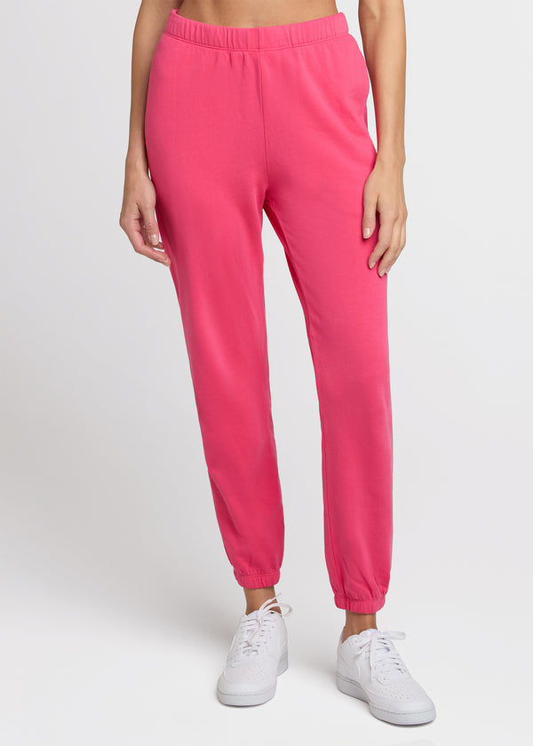Woman in pink sweatpant standing with her hands at her side. Front. 