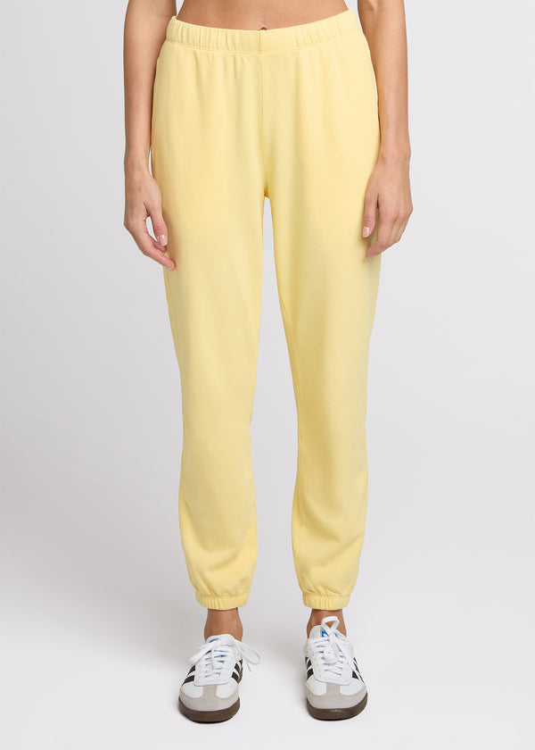 Woman in yellow sweatpant standing with her hands at her side. Front. 